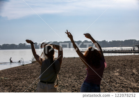 Joyful Friends Having Fun and Dancing Together by the Beautiful Water in the Morning Joyful Friends Having Fun and Dancing Together by the Beautiful Water in the Morning 122078252