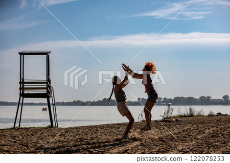 Joyful Beach Playtime Children are Happily Enjoying a Wonderful and Sunny Day by the Ocean 122078253