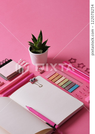 Stationery background with open notebook with stationery in pink theme. Space for your text. Stationery background with open notebook with stationery in pink theme. Space for your text. 122078254