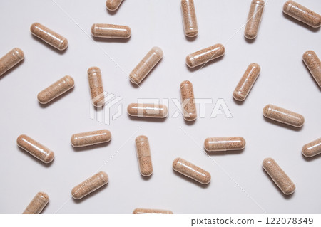 Capsules of dietary supplement are scattered on beige background. 122078349