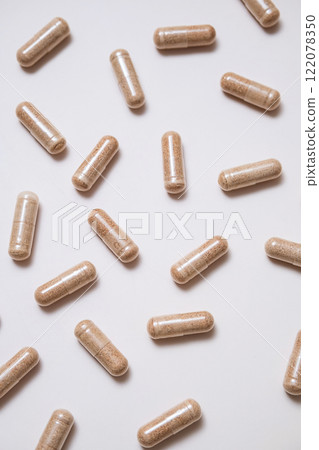 Capsules of dietary supplement are scattered on beige background. 122078350