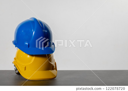 Construction helmets in blue and yellow ensure worker protection and visibility 122078720