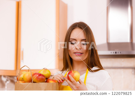Woman housewife in kitchen with many fruits 122079825