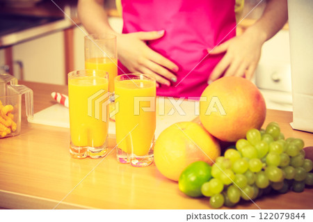 Woman with fresh fruits and juice in kitchen Woman with fresh fruits and juice in kitchen 122079844