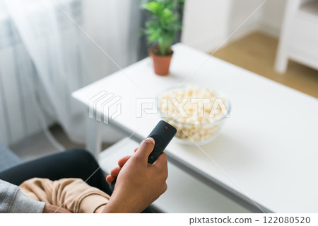 Remote control is pointed toward the television screen, control and choice of tv entertainment. TV, series and streaming service concept Remote control is pointed toward the television screen, control and choice of tv entertainment. TV, series and streaming service concept 122080520