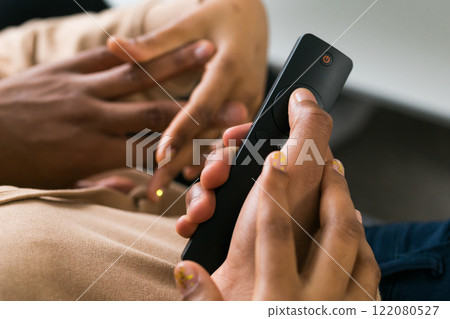 Remote control is pointed toward the television screen, control and choice of tv entertainment. TV, series and streaming service concept Remote control is pointed toward the television screen, control and choice of tv entertainment. TV, series and streaming service concept 122080527