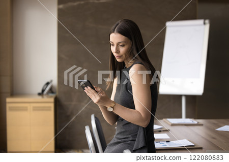 Young attractive businesslady using her smartphone in office Young attractive businesslady using her smartphone in office 122080883