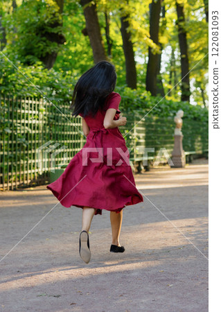 View from back, young African American woman in burgundy maxi dress, adorable female model posing 122081093