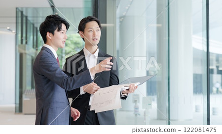 Businessmen holding drawings and having a meeting 122081475