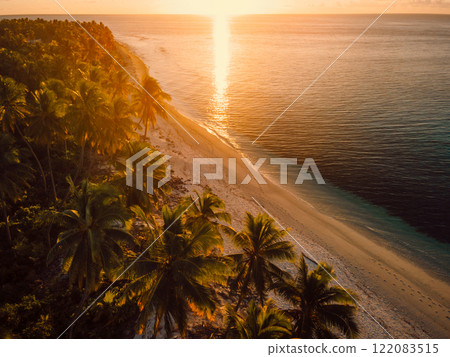 Warm sunset on Maldives tropical beach with palms trees and ocean. Above view 122083515