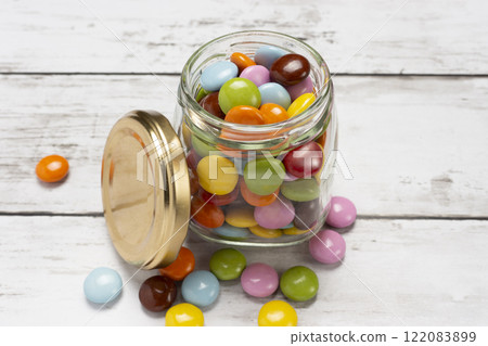 Colorful chocolate pieces in a glass jar 122083899