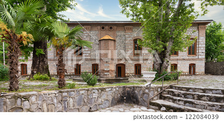 Imam Ali Mosque, a historical mosque stands in a courtyard surrounded by greenery, Shaki, Azerbaijan 122084039