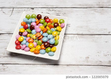 方形盤子上的彩色巧克力片 122085070