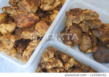 Three plastic containers filled with spiced chicken 122086282