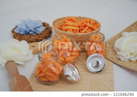 Crispy Corn Puffs in rattan and jar on bamboo mat. Selective focus. Crispy Corn Puffs in rattan and jar on bamboo mat. Selective focus. 122086290