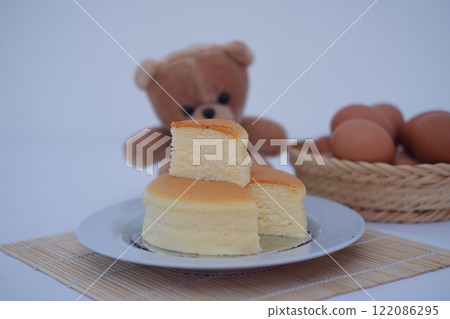 Cheesecake on white plate and eggs on bamboo mat Cheesecake on white plate and eggs on bamboo mat 122086295