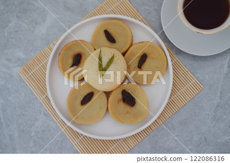Kue Lumpur or Mud Cake, Indonesian traditional cake made from potato, flour, eggs and coconut milk topped with raisins served on plate. beautiful decoration 122086316