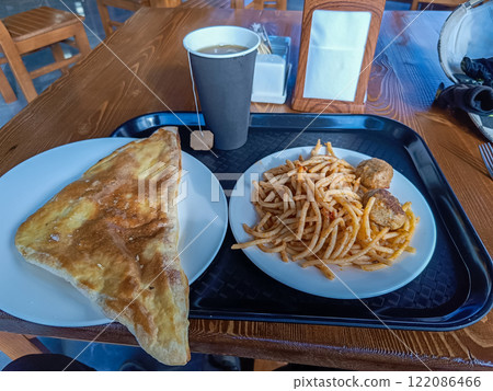 Enjoying a delicious meal of pasta and pastry in a cozy restaurant 122086466
