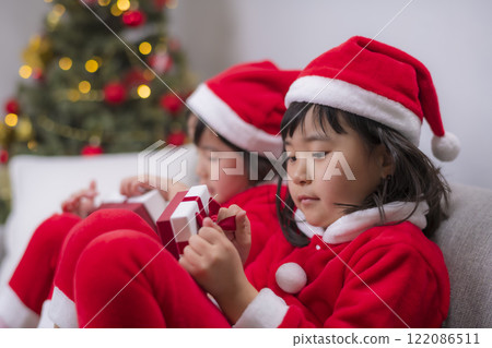 身著聖誕老人服裝的姊妹們打開聖誕禮物的那一刻 122086511