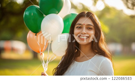A beautiful Indian woman carrying balloons. The color of the balloons symbolize the Indian flag 122086583