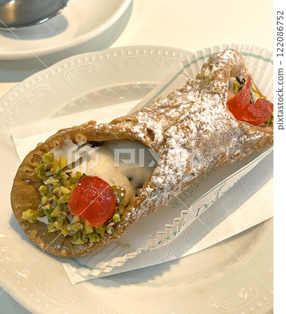 Canoli with pistachios on saucer. Food and drink. Traditional Italian dessert.  122086752