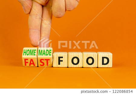 Fast or homemade food symbol. Concept words Fastfood or Homemade food on wooden cubes. Beautiful orange table orange background. Doctor hand Healthy lifestyle Fast or homemade food concept. Copy space 122086854