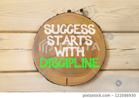 Success starts with discipline symbol. Concept words Success starts with discipline on beautiful wooden circle. Beautiful wooden background. Business success starts with discipline concept. Copy space Success starts with discipline symbol. Concept words Success starts with discipline on beautiful wooden circle. Beautiful wooden background. Business success starts with discipline concept. Copy space 122086930