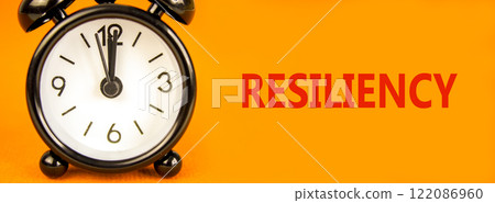 Resiliency symbol. Concept word Resiliency on beautiful orange paper. Beautiful orange paper background. Black alarm clock. Business resiliency concept. Copy space. Resiliency symbol. Concept word Resiliency on beautiful orange paper. Beautiful orange paper background. Black alarm clock. Business resiliency concept. Copy space. 122086960