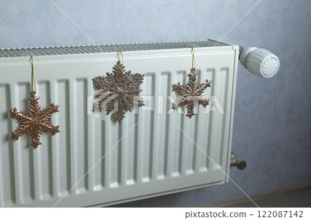 snowflakes on a radiator in a room of an apartment building snowflakes on a radiator in a room of an apartment building 122087142