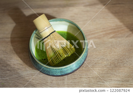 Matcha tea with bamboo whisk on wooden table 122087924
