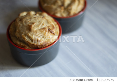 Two souffle in heat-resistant forms on a wooden table 122087979