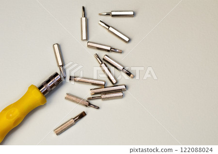 Screwdriver and bits on a gray background Screwdriver and bits on a gray background 122088024