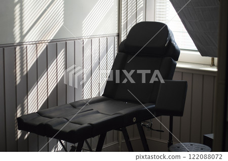 Interior of a beauty salon. Workspace with black massage chair Interior of a beauty salon. Workspace with black massage chair 122088072