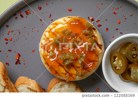Portion of baked brie with jalapeno and toast Portion of baked brie with jalapeno and toast 122088169