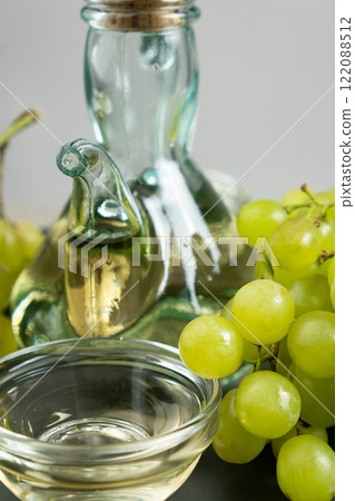 White wine vinegar in a vinegar bowl among grapes 122088512