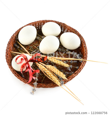 Easter eggs in a wicker basket isolated on a white. Easter eggs in a wicker basket isolated on a white. 122088756