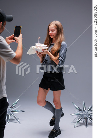 A young model showcases a delightful dessert in a creatively arranged studio photo shoot 122089026