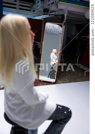 A Fashion Model Reflecting Gracefully in a Studio Mirror Captured in Artistic Detail A Fashion Model Reflecting Gracefully in a Studio Mirror Captured in Artistic Detail 122089029
