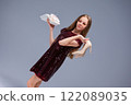 A Fashionable Young Girl, wearing High Heels, joyfully holding gifts in her hands 122089035