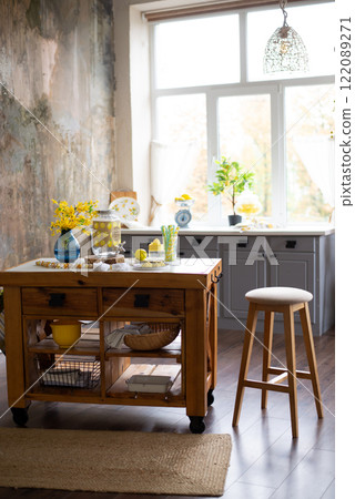 Cozy kitchen interior with a wooden table, stool, and rustic decor. a large window. 122089271