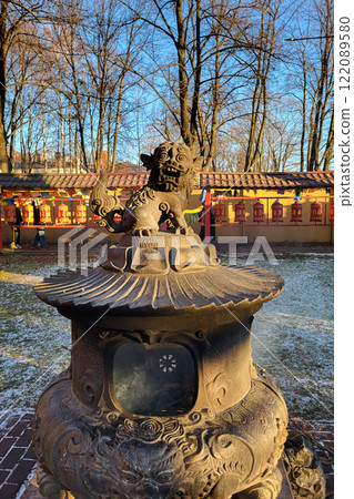 snow lion statue on top of a large bronze incense burner in the courtyard of a Buddhist Datsan Gunzechoinei 122089580