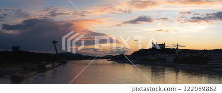 Wide sunset panorama of Bratislava with Danube river, SNP bridge and castle shot in Slovakia, Europe Wide sunset panorama of Bratislava with Danube river, SNP bridge and castle shot in Slovakia, Europe 122089862