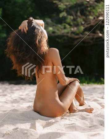 Attractive naked woman with perfect nudity body posing on ocean coastline 122090111