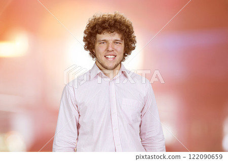 Portrait of a happy cheerful man with curly hair. Abstract red glowing background. Portrait of a happy cheerful man with curly hair. Abstract red glowing background. 122090659