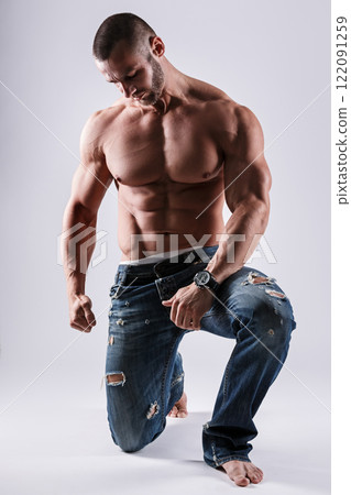 Handsome muscular man wearing jeans posing in studio 122091259