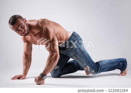 Handsome muscular man wearing jeans posing in studio Handsome muscular man wearing jeans posing in studio 122091264