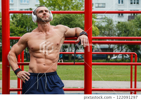 Man listening music during his street workout Man listening music during his street workout 122091297