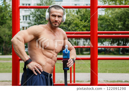 Man listening music during his street workout Man listening music during his street workout 122091298