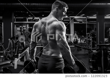 Muscular man with dumbbells in the gym 122091323