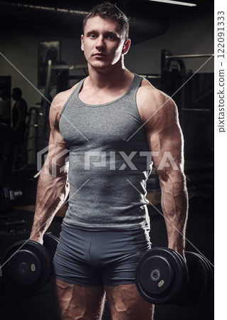 Muscular man with dumbbells in the gym 122091333